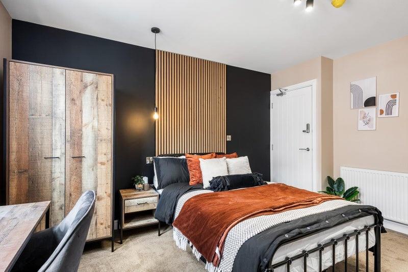 A stylish double bedroom featuring a cozy bed w...