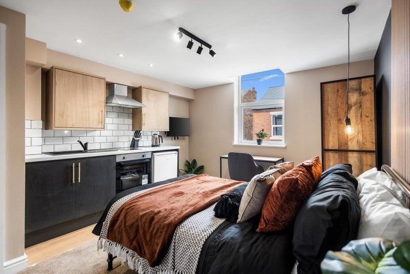 A modern and stylish studio bedroom featuring a...