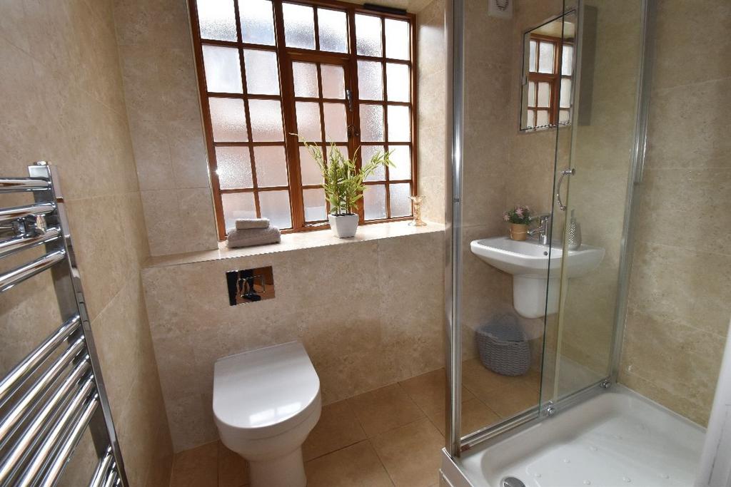 Bright and modern bathroom suite featuring a gl...