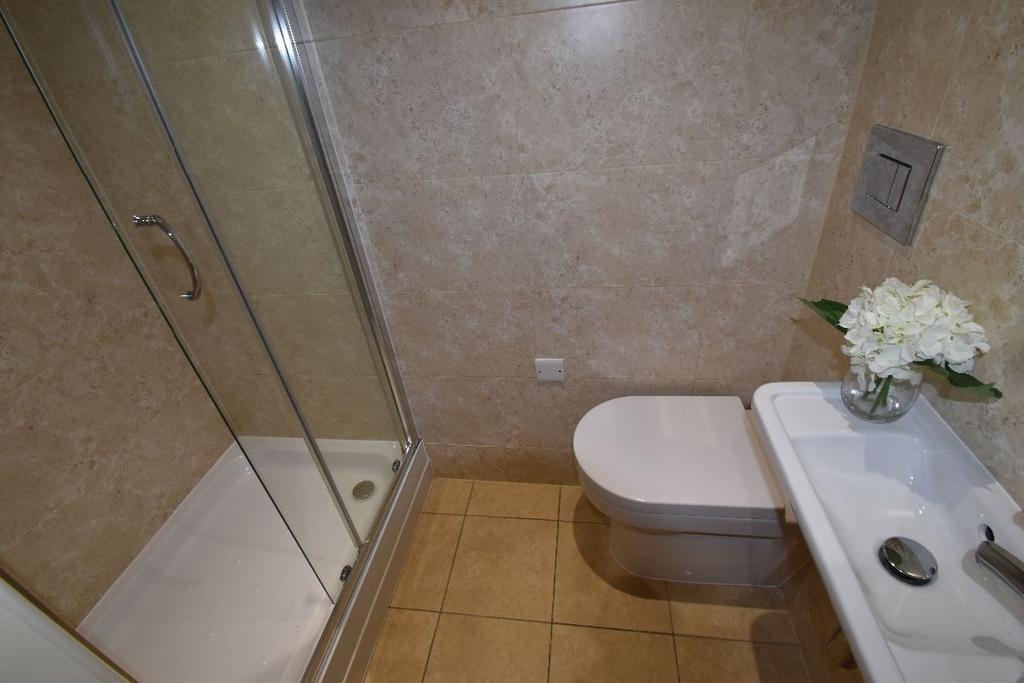 A clean and modern bathroom featuring a glass-e...