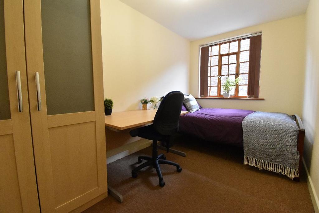 Cozy single bedroom featuring a comfortable bed...