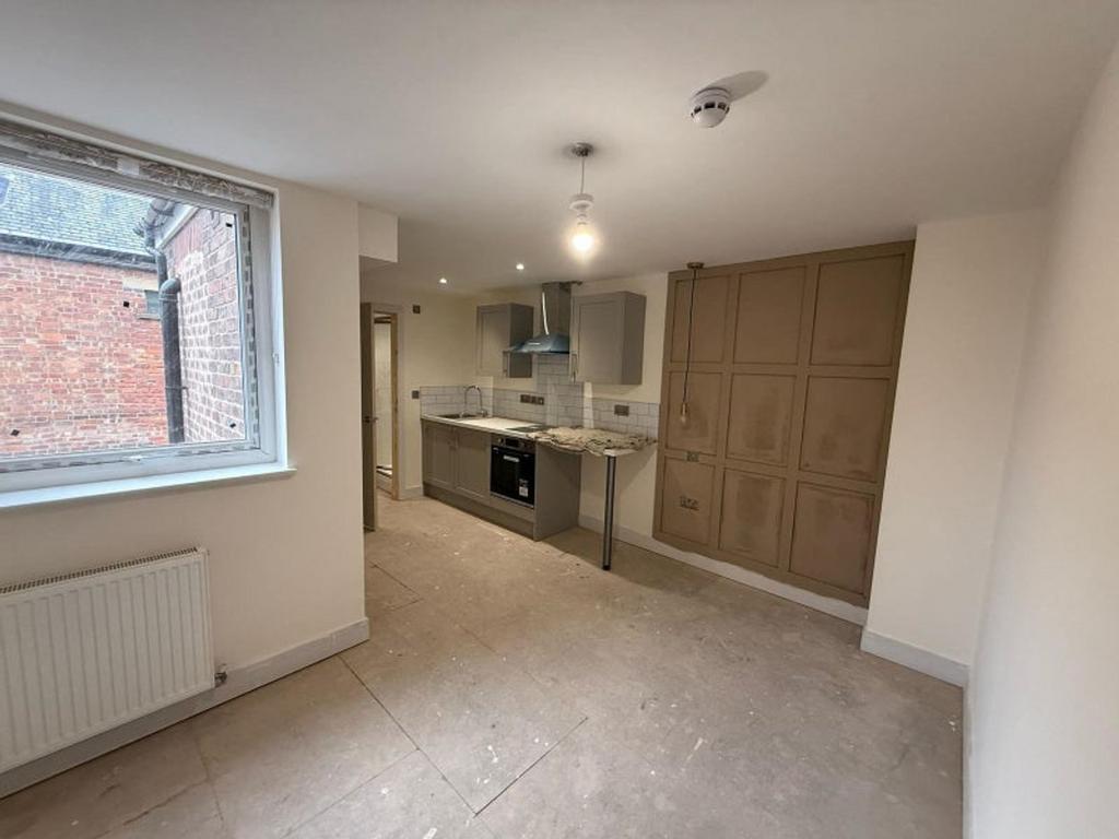 A bright and modern kitchen featuring sleek cab...
