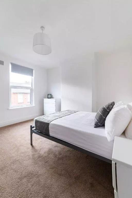 A bright and clean double bedroom featuring a c...