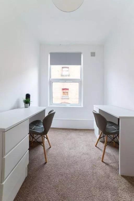 Bright and tidy communal workspace featuring tw...