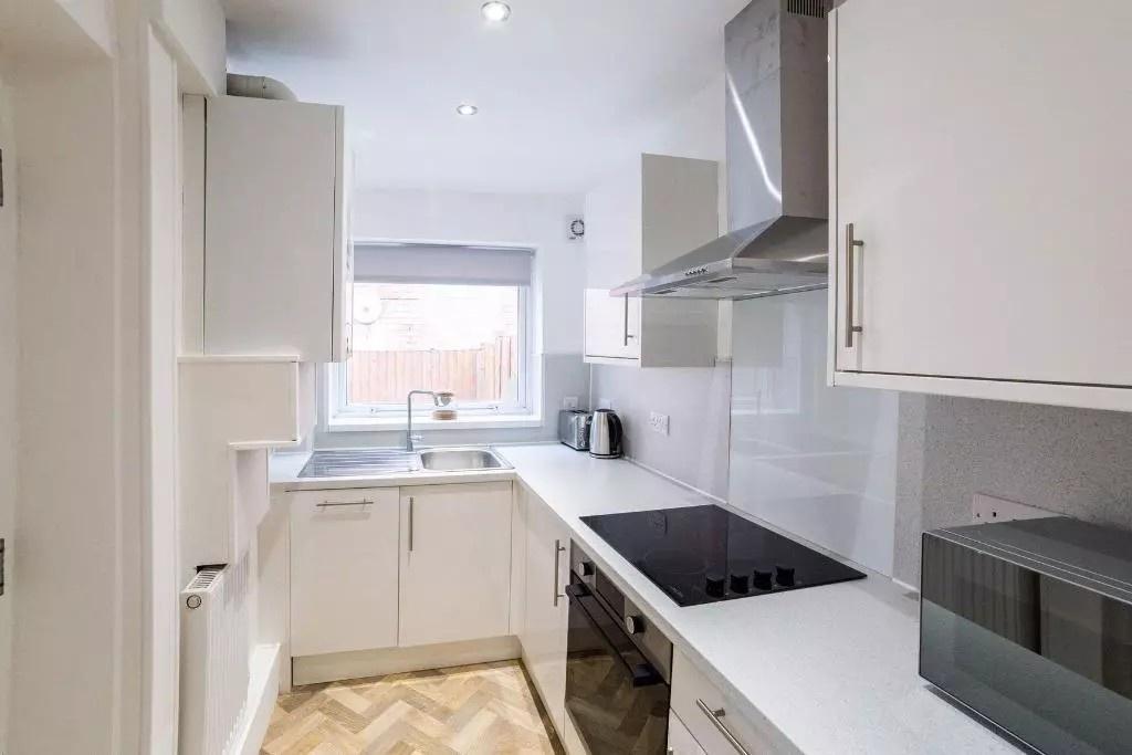 Bright and modern kitchen with sleek white cabi...