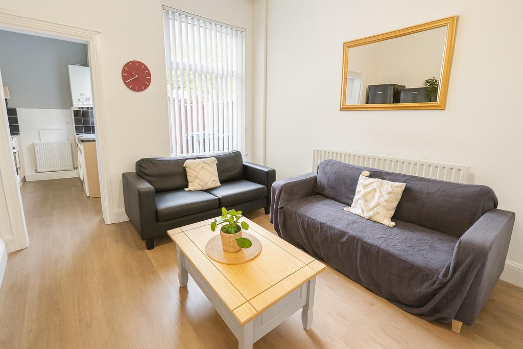 A bright and tidy living room featuring two com...