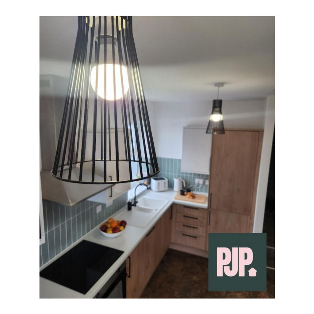 This modern kitchen features stylish wooden cab...