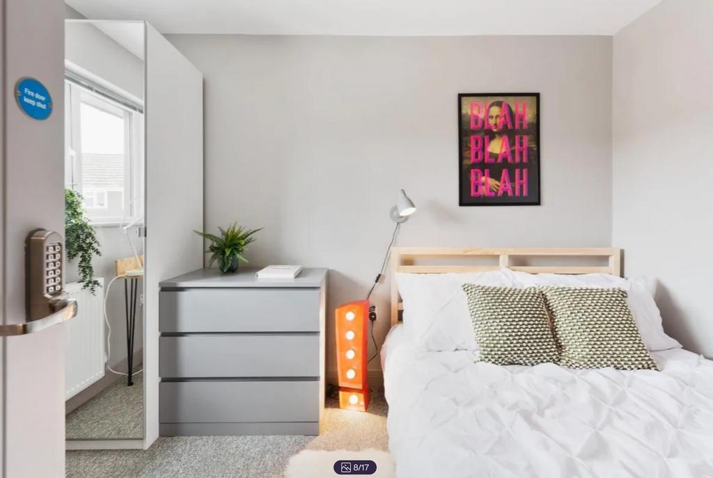 A bright and modern double bedroom featuring st...
