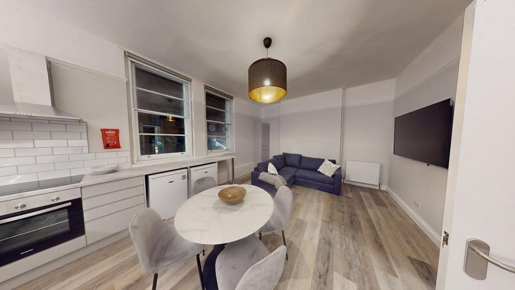A modern kitchenette with a cozy dining area, p...