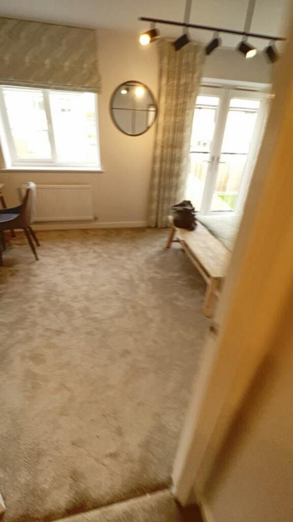 A cozy living room featuring ample natural ligh...