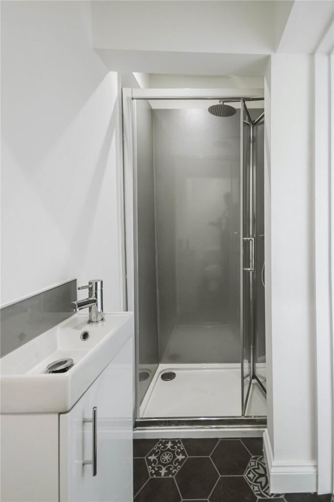 A modern compact bathroom featuring a sleek sho...