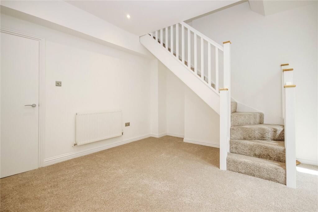 Bright and clean hallway featuring a neutral ca...