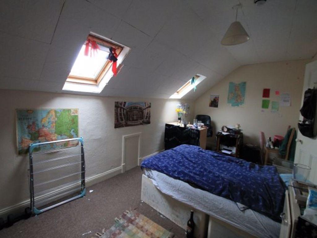 A cozy attic master bedroom featuring angled sk...