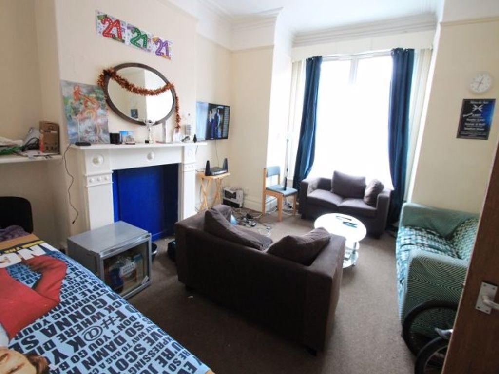 A cozy and well-lit single bedroom featuring a ...