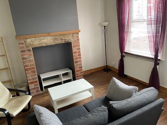 A cozy living room featuring a comfortable grey...