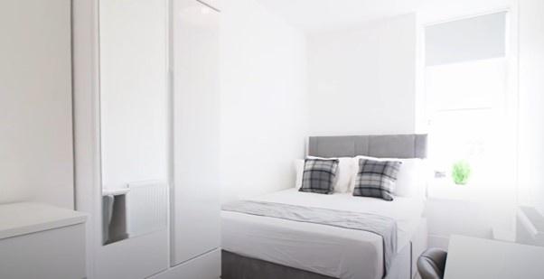 Bright and clean double bedroom featuring a com...