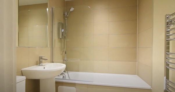 A modern and clean bathroom featuring a full ba...