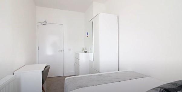 A neat and functional single bedroom featuring ...