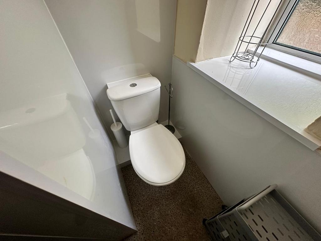 A clean and modern single toilet with ample nat...