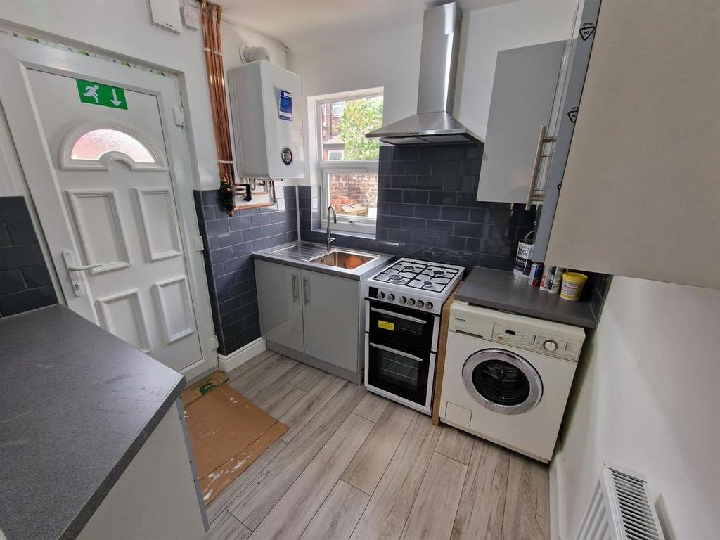 A compact, modern kitchen featuring clean count...