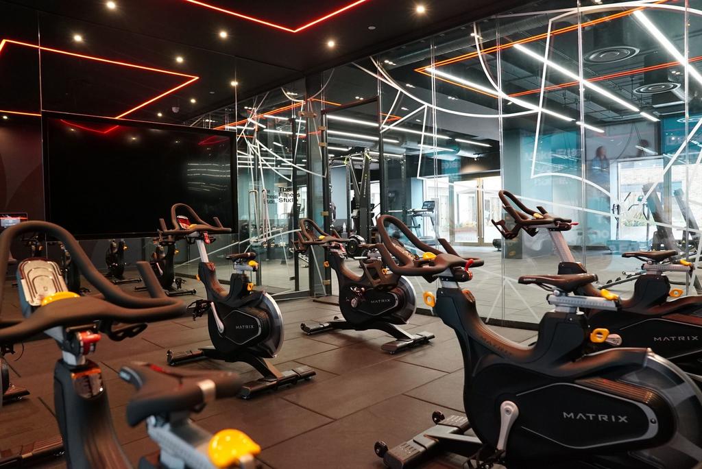 Modern gym space featuring multiple stationary ...