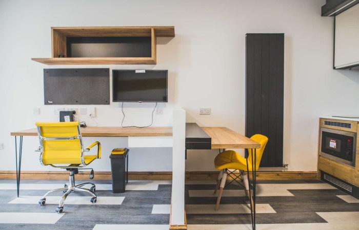 A modern communal workspace featuring a clean, ...
