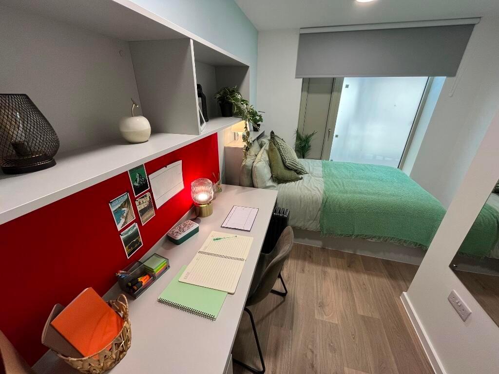 A neat and well-organized single bedroom featur...