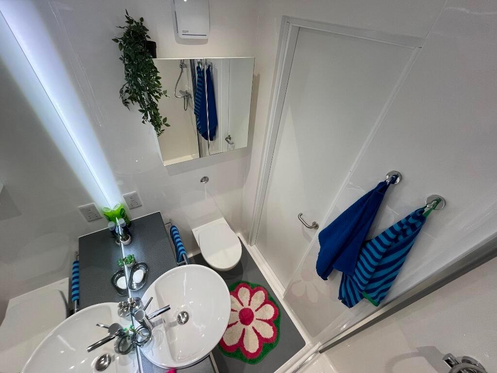 A bright and clean bathroom featuring a white s...