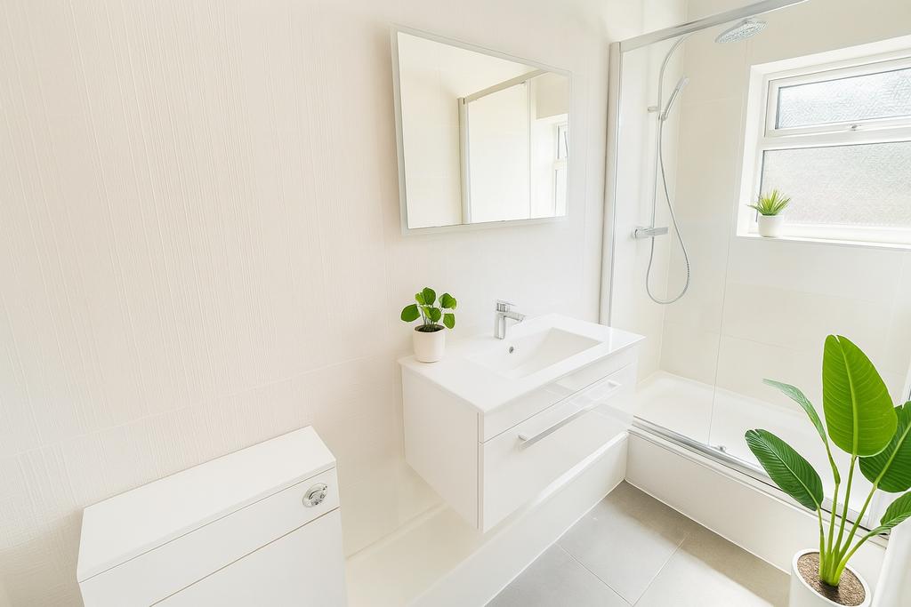 Bright and modern bathroom featuring a sleek wh...