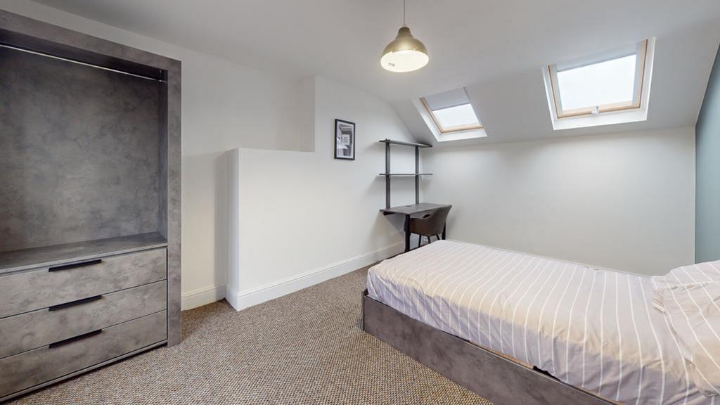 A bright and tidy double bedroom featuring mode...