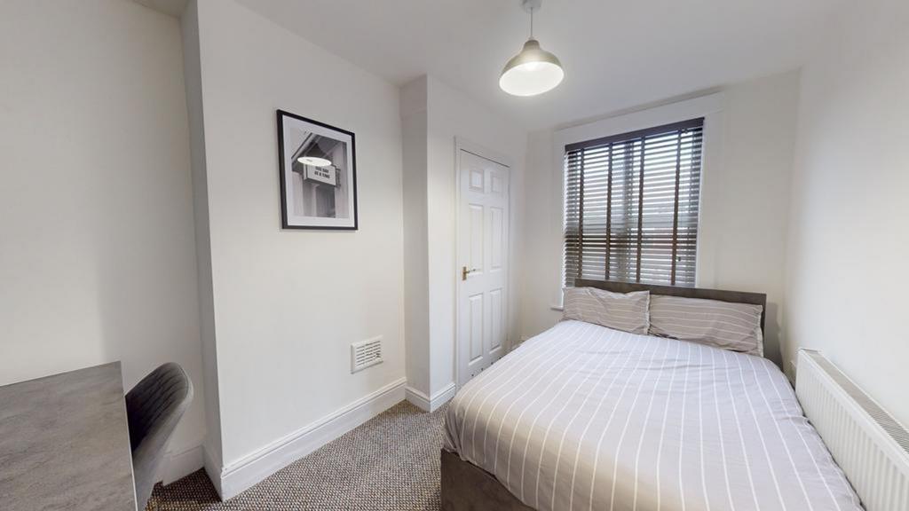 A bright and inviting double bedroom with moder...