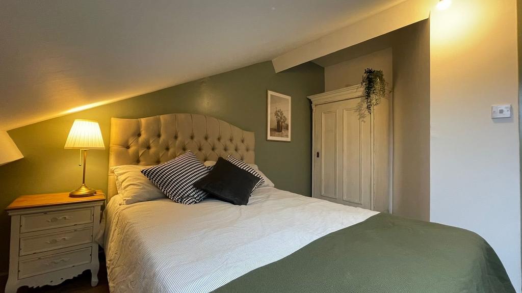 A cozy and well-decorated double bedroom featur...