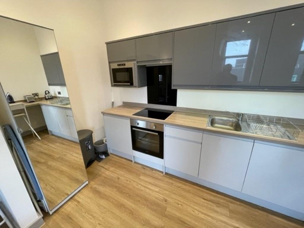 Modern kitchen with sleek grey cabinets, built-...