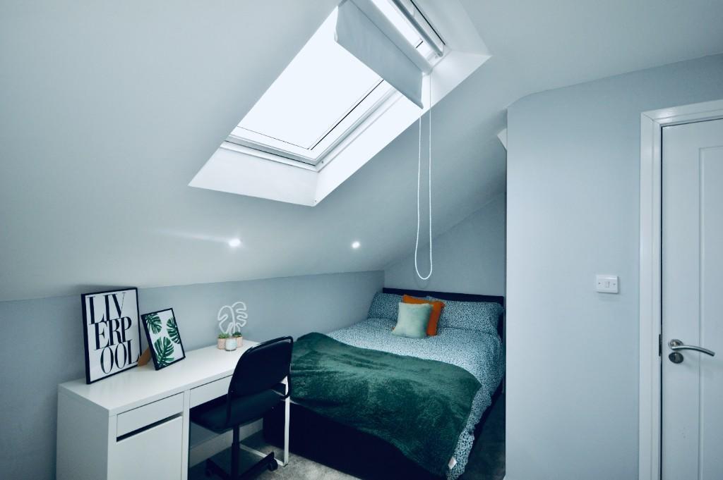 This inviting double bedroom features a cozy la...