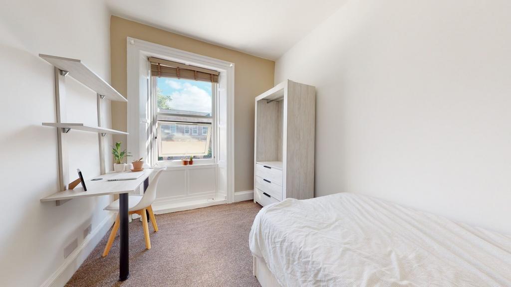 A bright and inviting double bedroom with a stu...