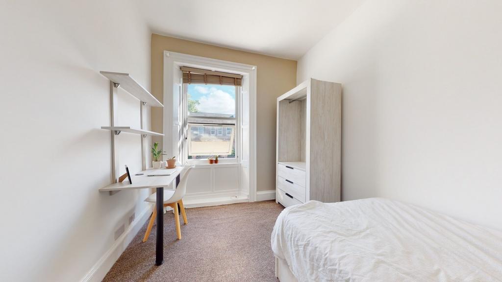 A bright and tidy double bedroom featuring a st...