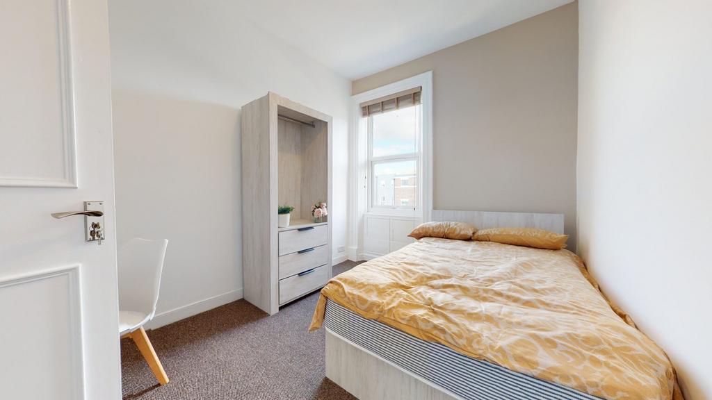 A bright and inviting double bedroom with styli...