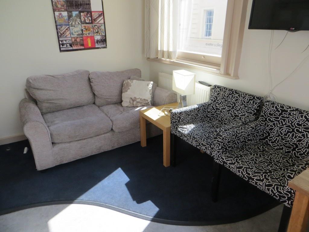 A cozy communal lounge with a comfortable grey ...
