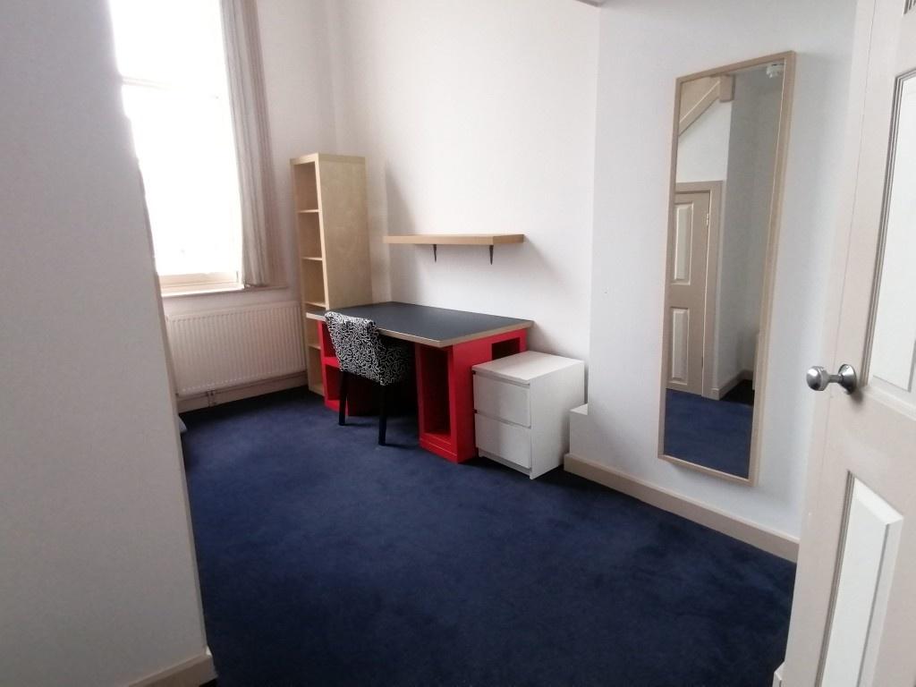 A clean and tidy room featuring a practical des...