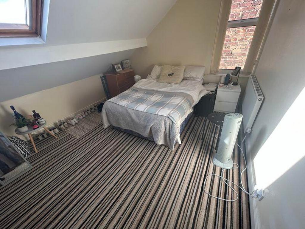 A bright and cozy double bedroom featuring a co...