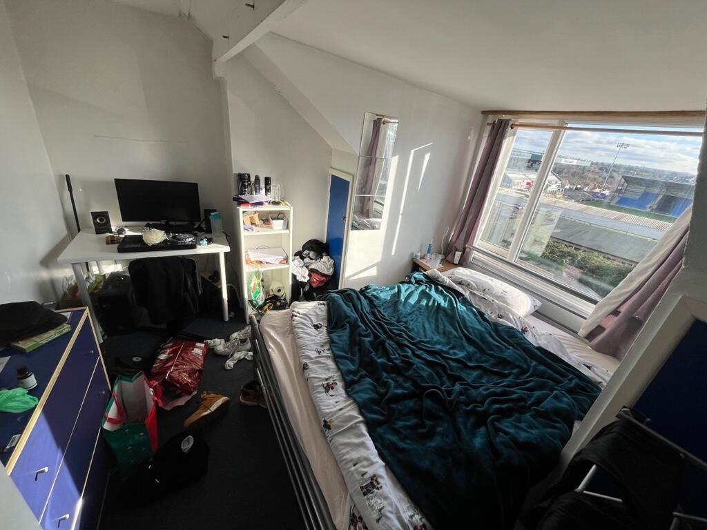 Bright master bedroom featuring a large window ...