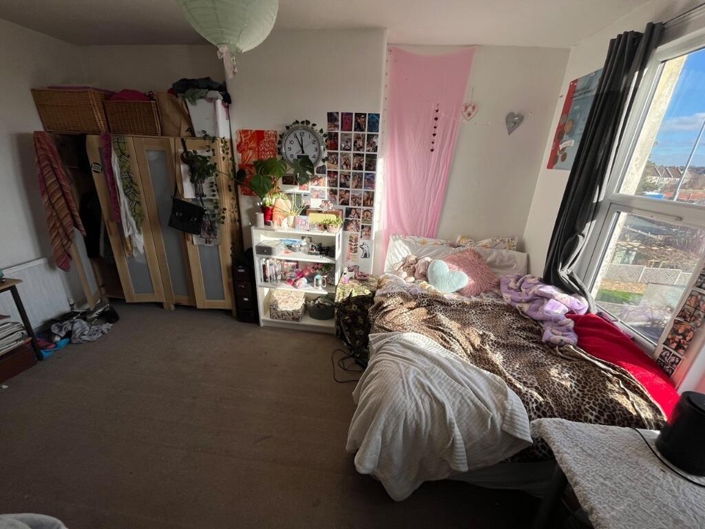 A cozy single bedroom featuring a large window ...