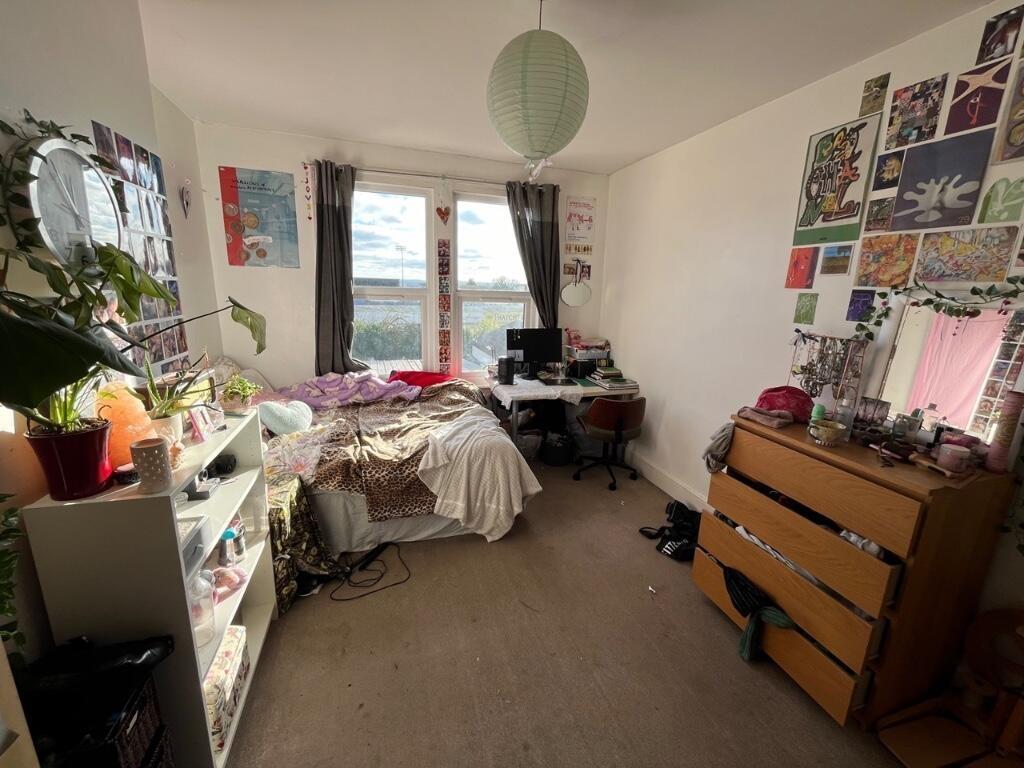 Cozy master bedroom featuring a large window th...