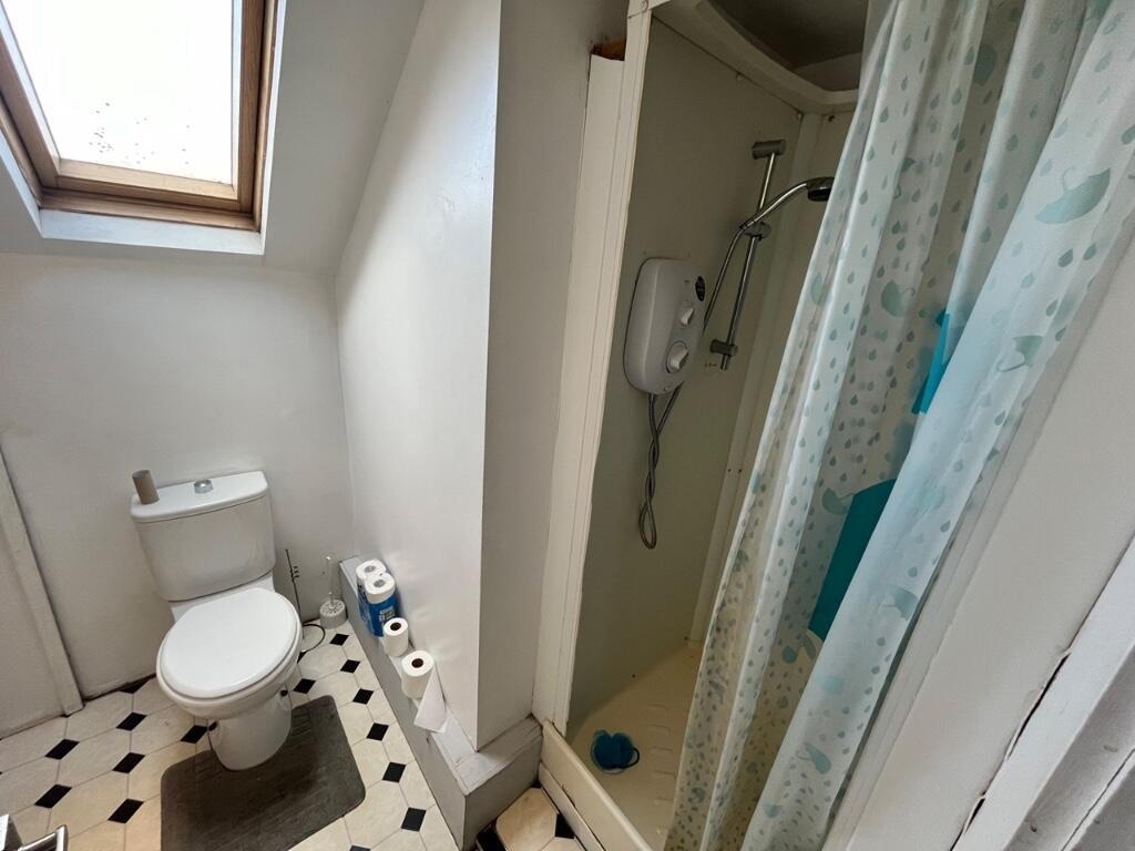 A compact bathroom featuring a toilet and a sho...