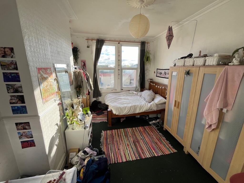 Cozy single bedroom featuring a large window wi...