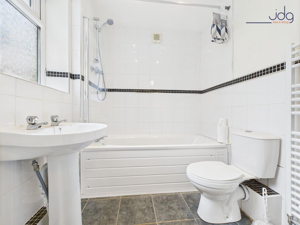 Fully tiled ground floor bathroom with overhead...