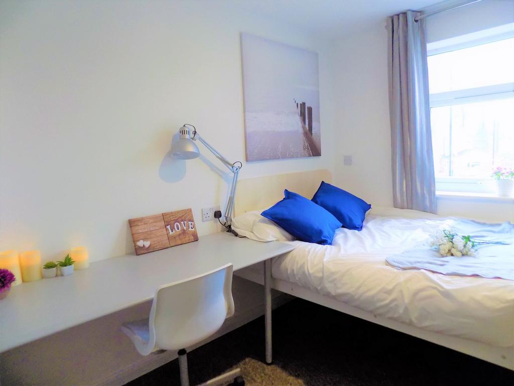 A bright and tidy single bedroom featuring a co...