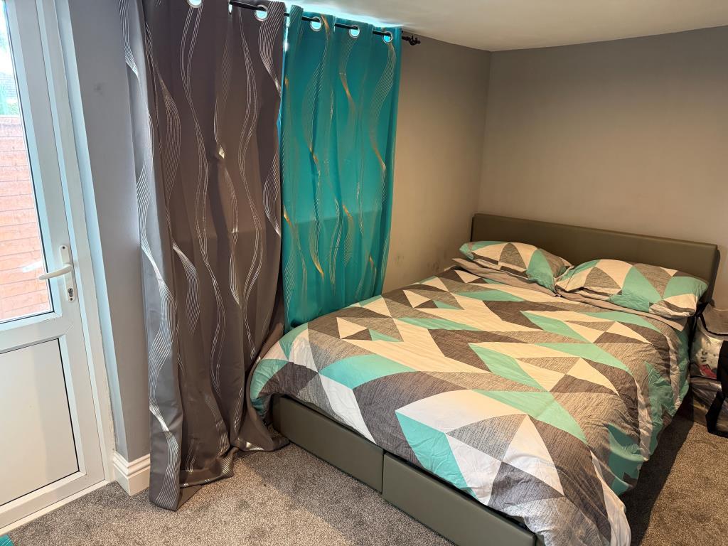 Main bedroom with glazed door to rea garden