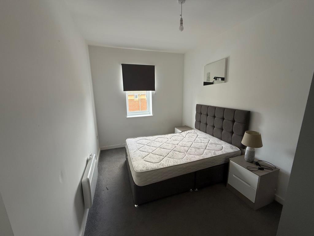 Bedroom with white painted walls and grey flooring