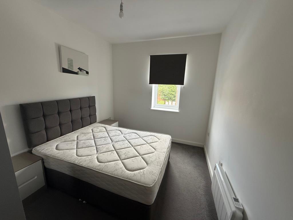 Bedroom with white painted walls and grey flooring